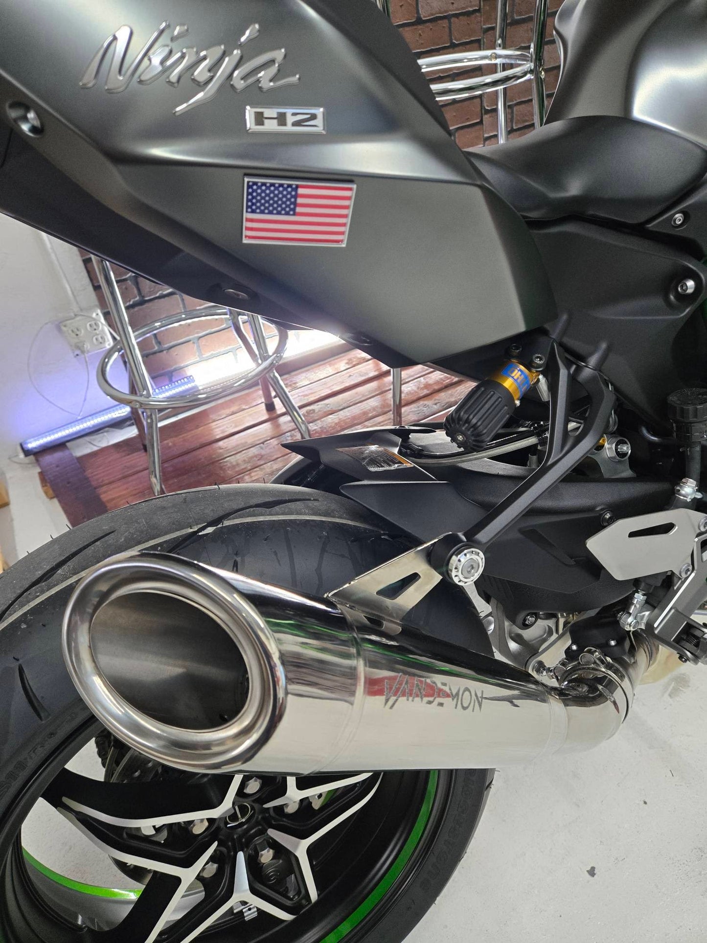 Close-up of a motorcycle with an American flag sticker on the exhaust and seat.