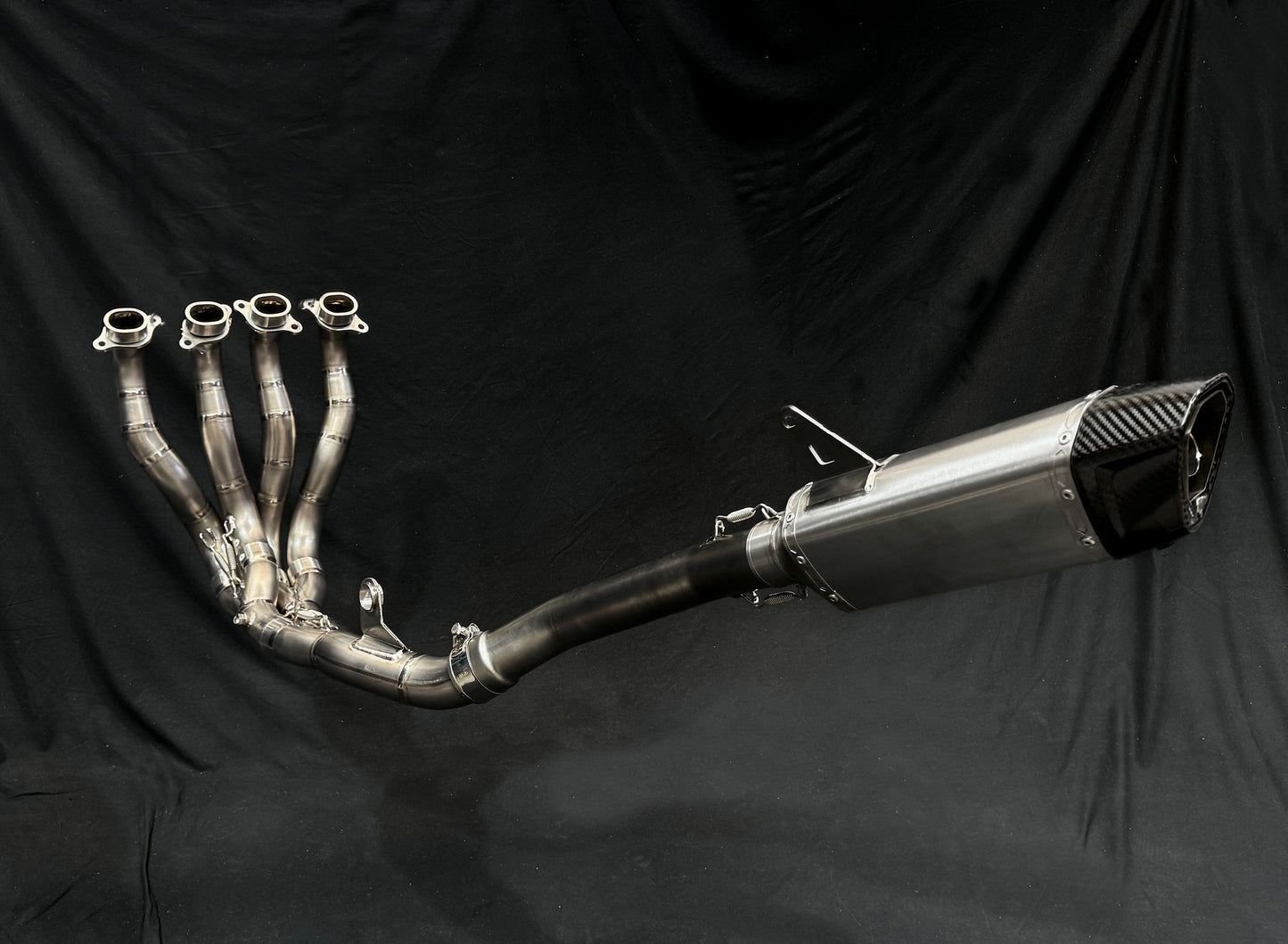 a motorcycle exhaust pipe set against a black backdrop