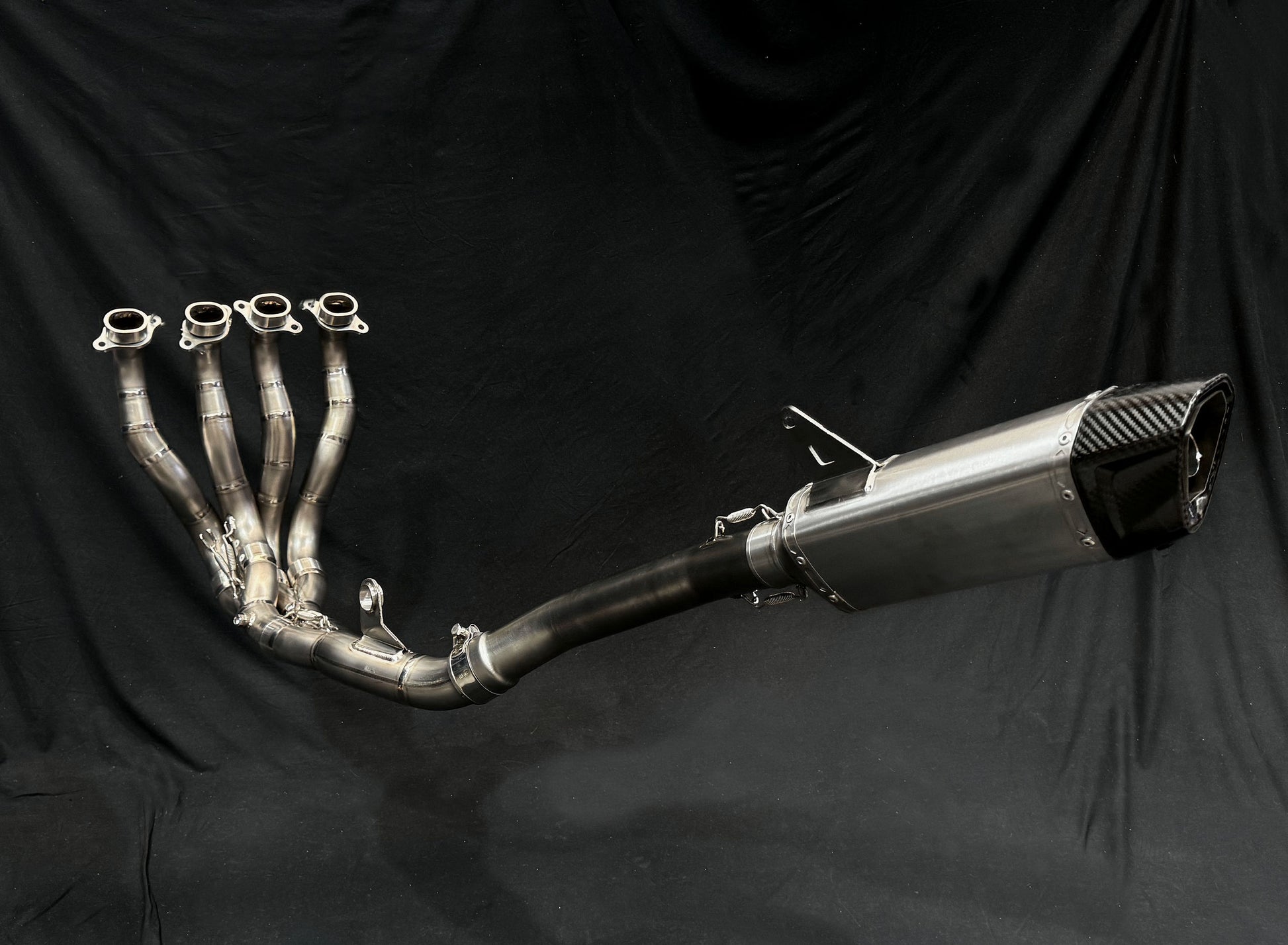 a motorcycle exhaust pipe set against a black backdrop
