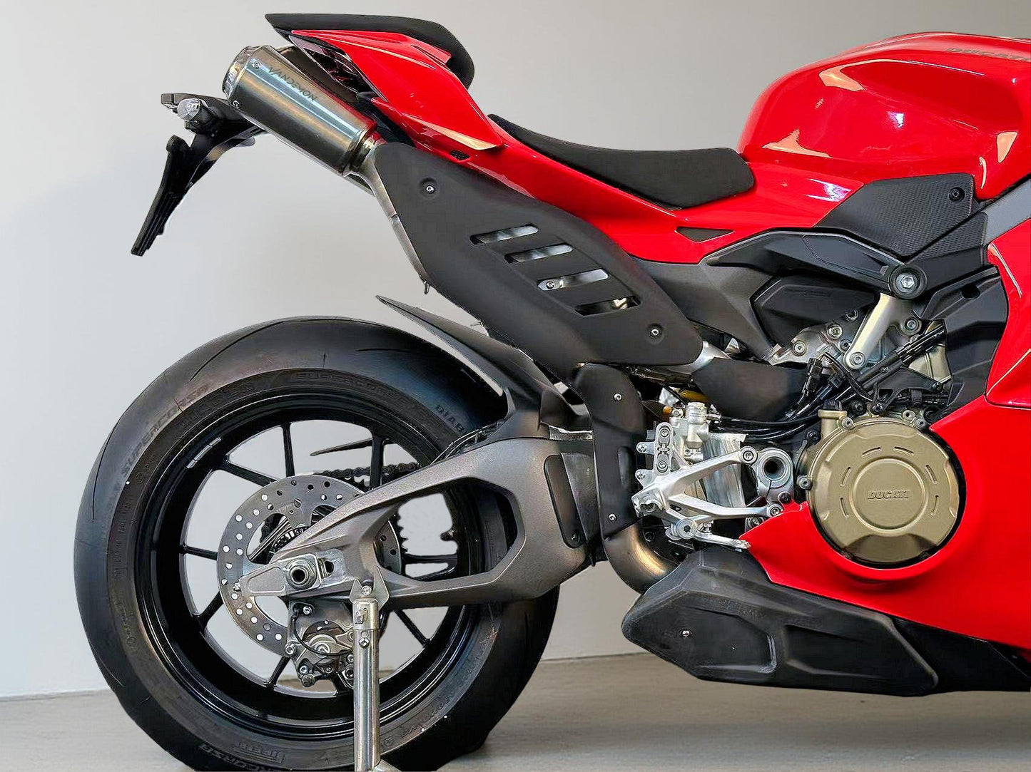 2025 Ducati Panigale Red motorcycle with black seat and exhaust on a light grey background