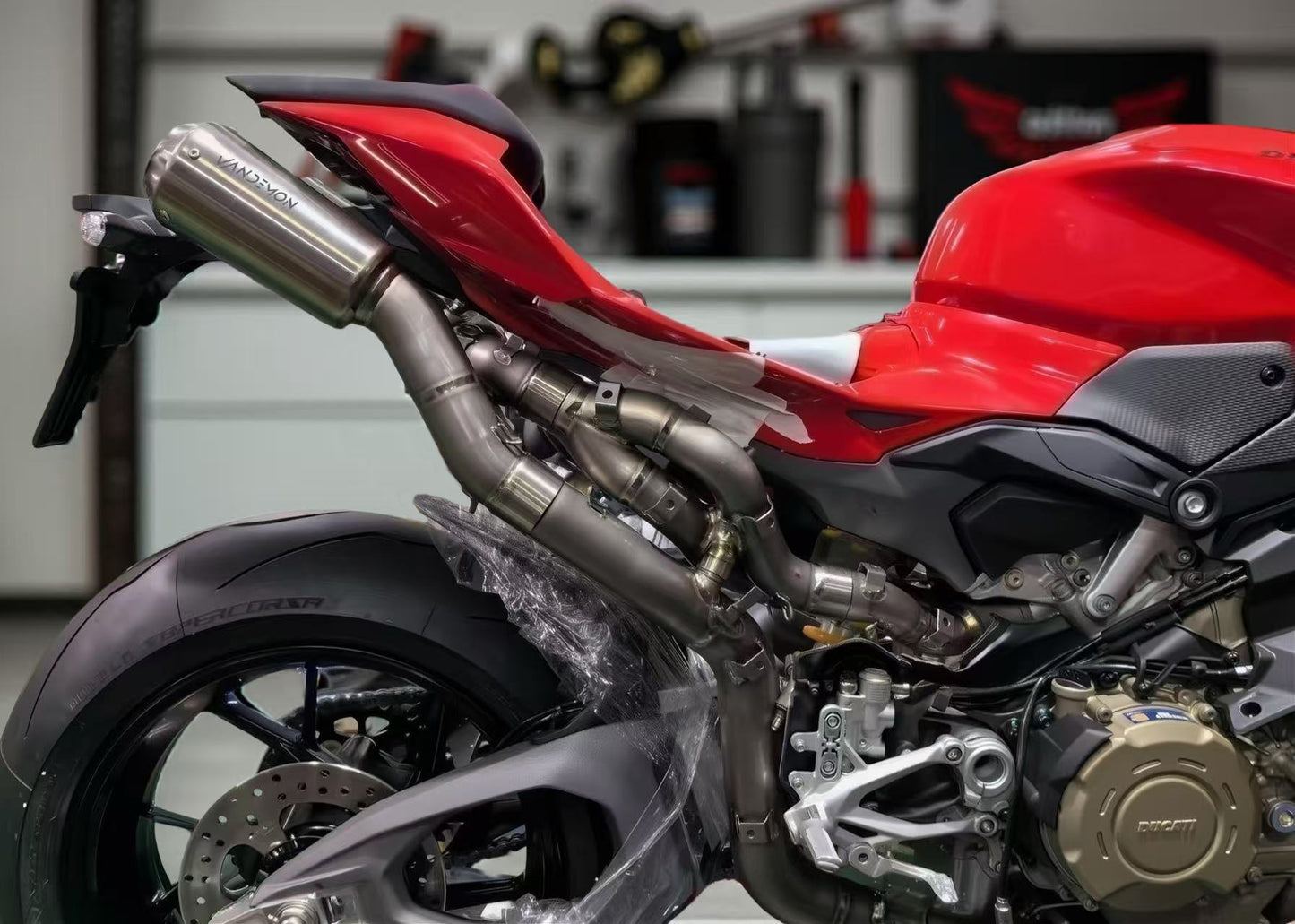 Close-up of a 2025 Panigale red motorcycle with a metallic exhaust in a garage setting