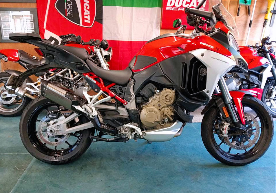 Red and black motorcycle on display with Ducati branding in the background