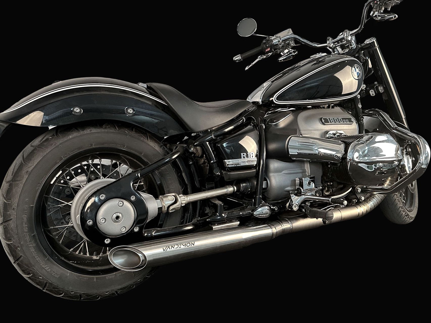 A motorcycle parked in a garage, showcasing its aluminium exahaust.