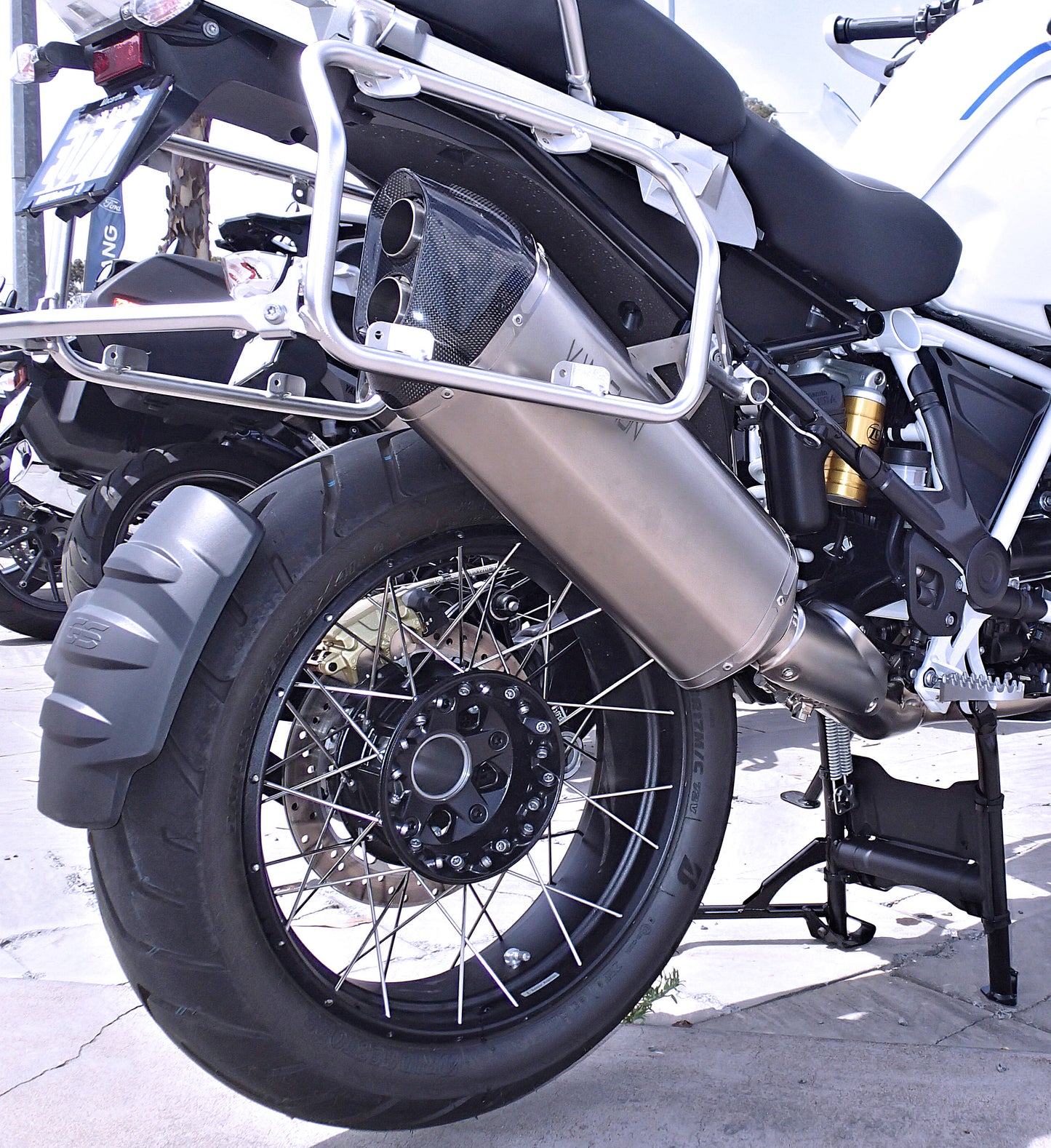 The image showcases the exhaust pipe, back tire, and part of the engine.