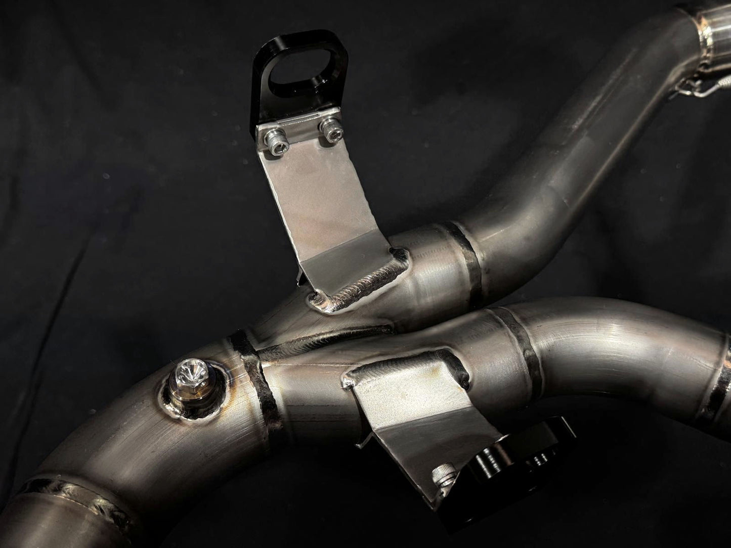 Detailed view of two exhaust pipesa connector positioned on a black surface