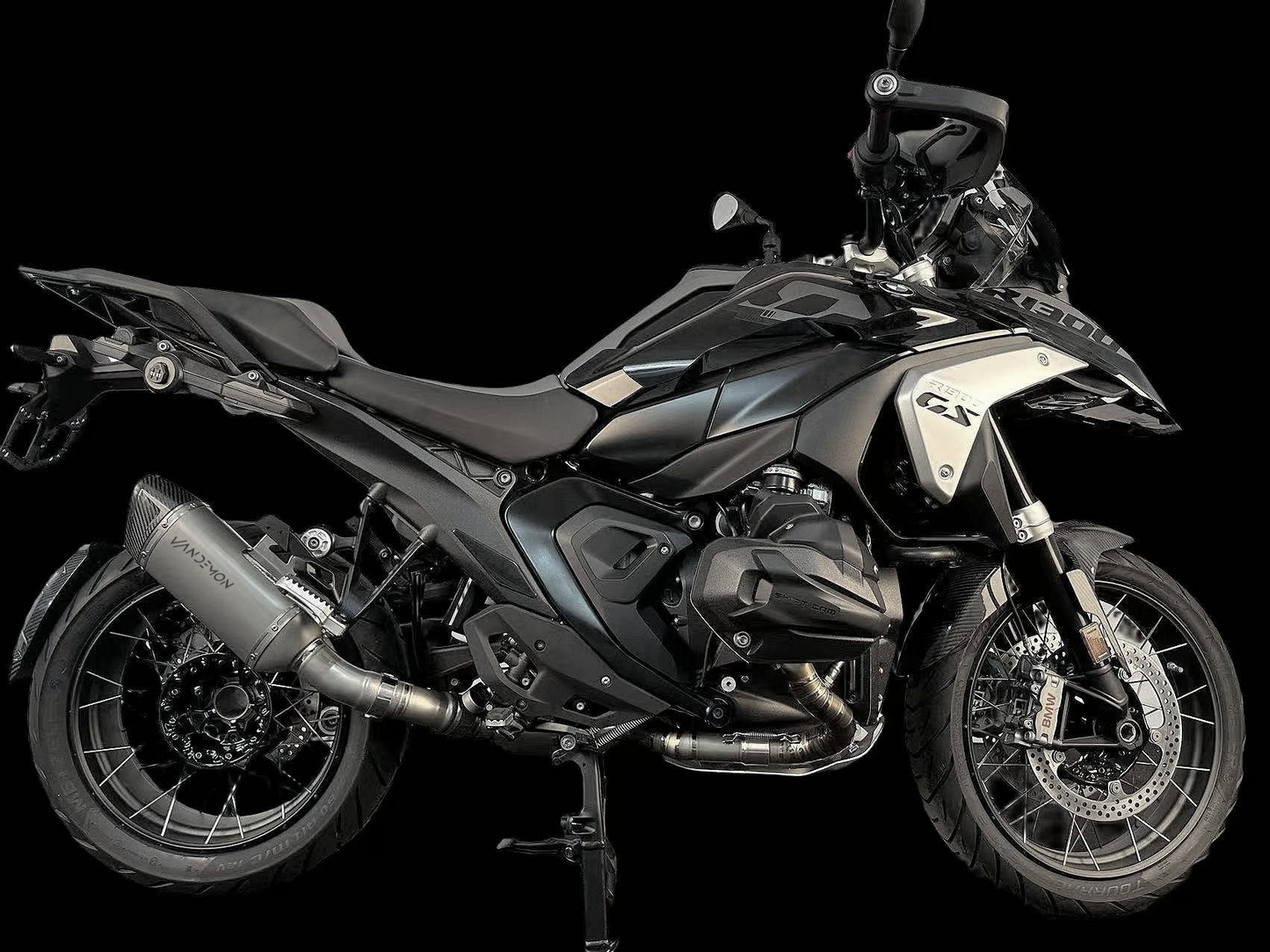 A black motorcycle positioned in front of a black background