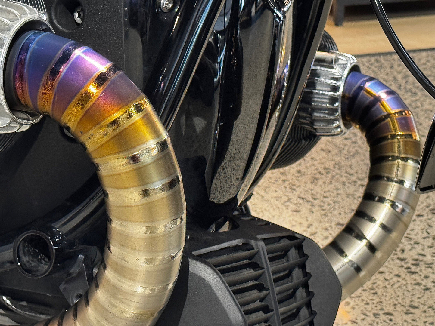 Detailed view of a motorcycle featuring strikingly colorful exhaust pipes, highlighting its unique design.