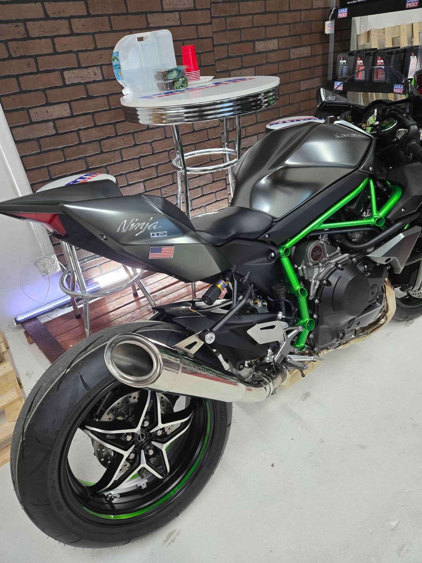Kawasaki Ninja motorcycle with green accents on a white floor