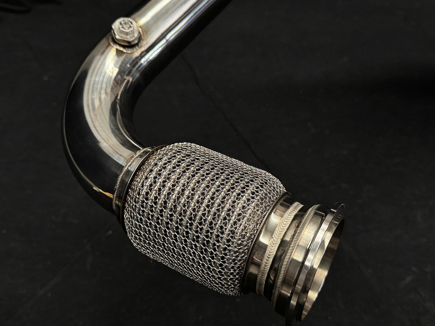 Light highlights modern design of motorcycle exhaust system.