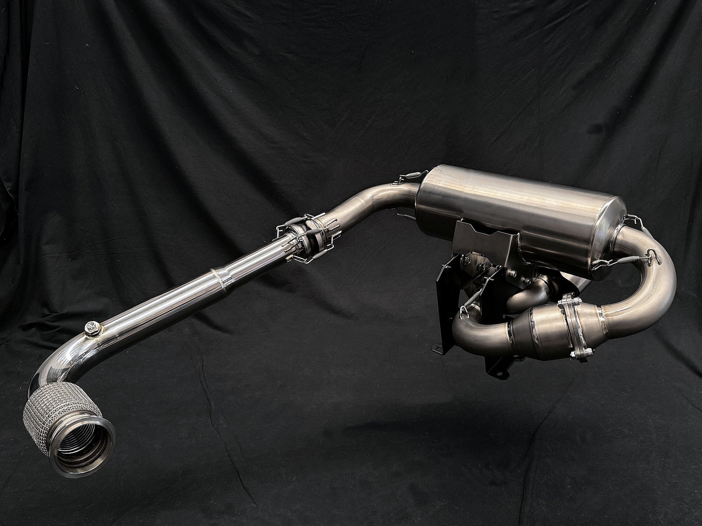 Motorcycle dual-exhaust with shiny finish against dark setting.