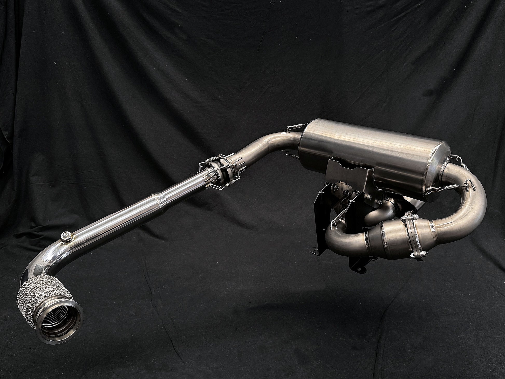 Motorcycle dual-exhaust with shiny finish against dark setting.