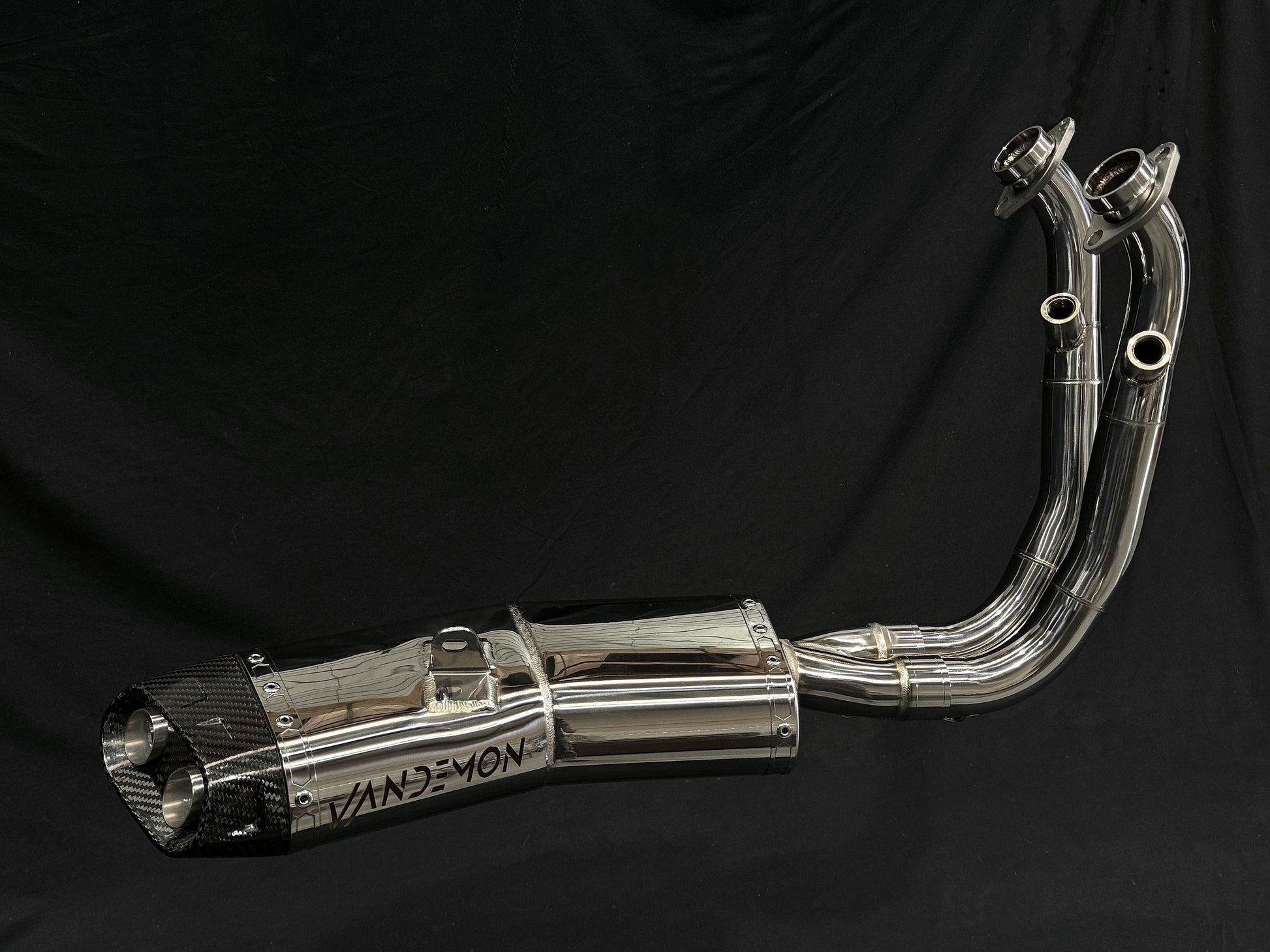 Detailed view of a motorcycle exhaust pipe set against a black backdrop
