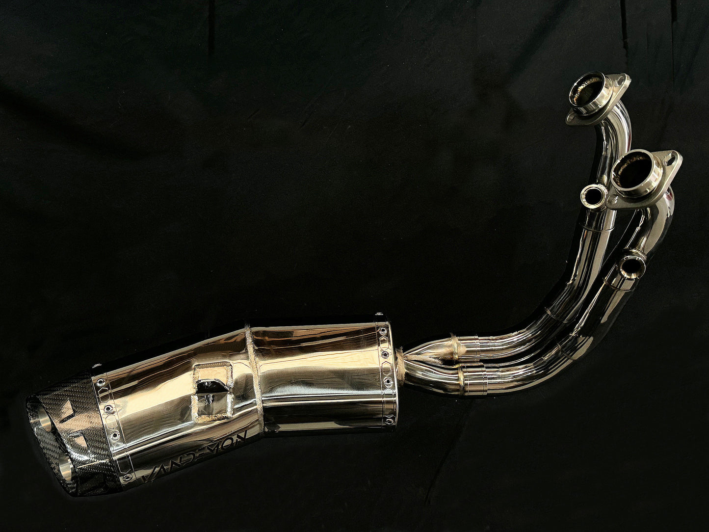 A sleek motorcycle exhaust pipe displayed on a black background