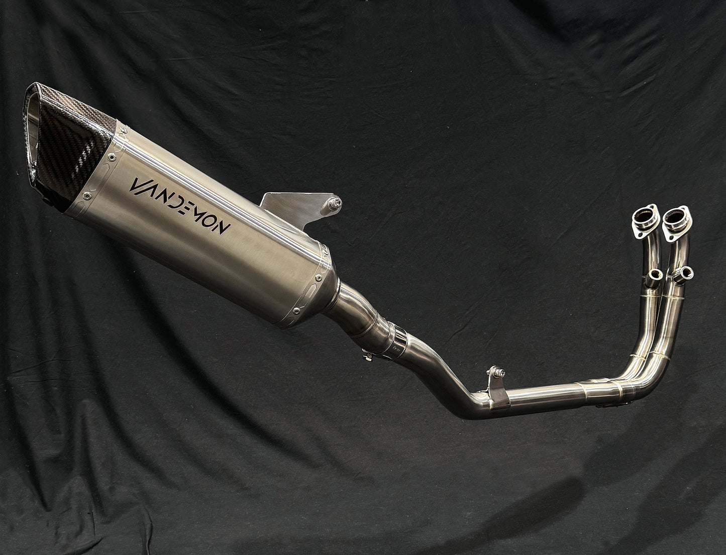 vandemon brushed stainless steel exhausts against a black backdrop.