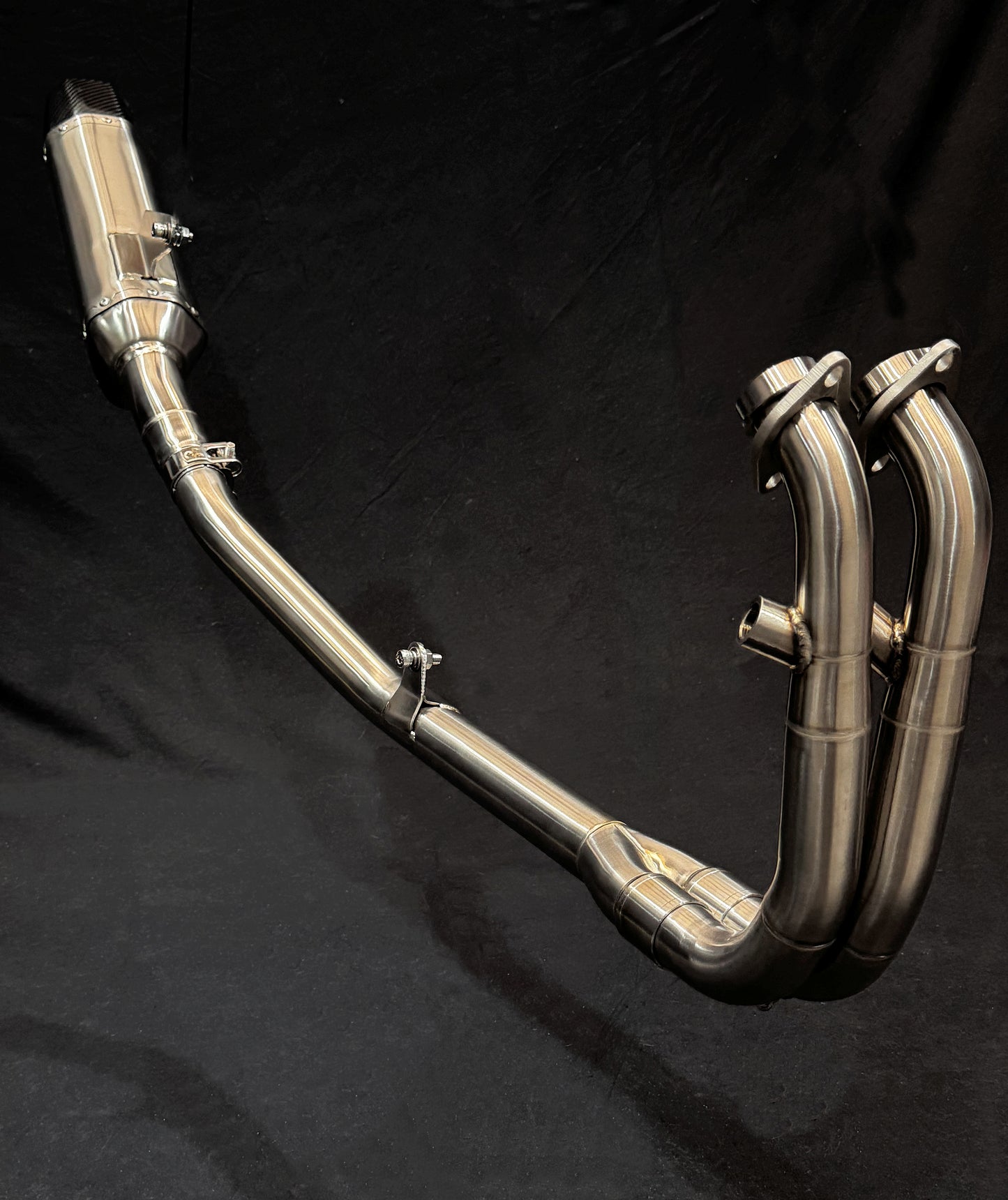 Brushed Stainless Steel Exhaust System with a black background.