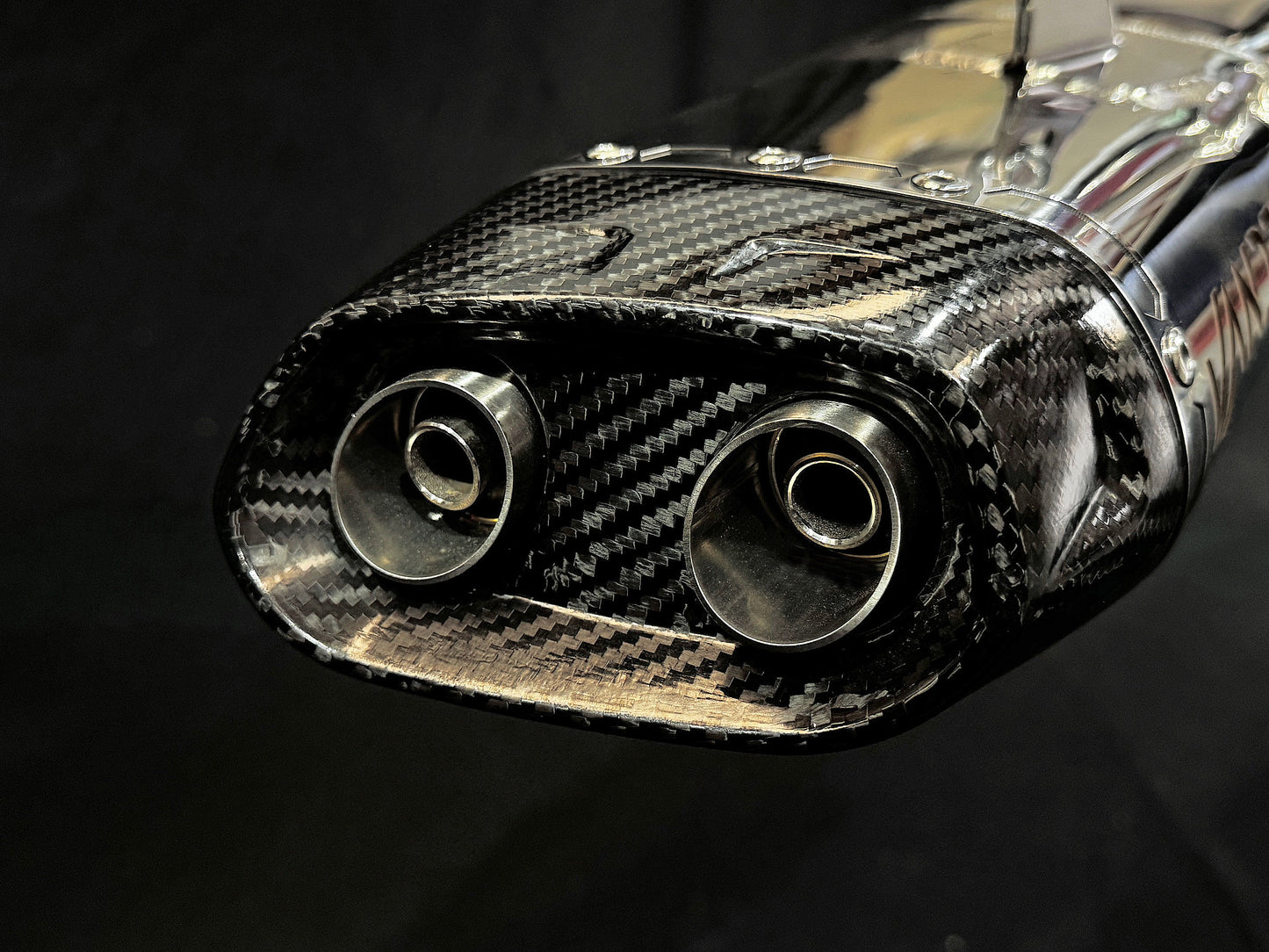 Detailed close-up of a carbon fiber exhaust pipe