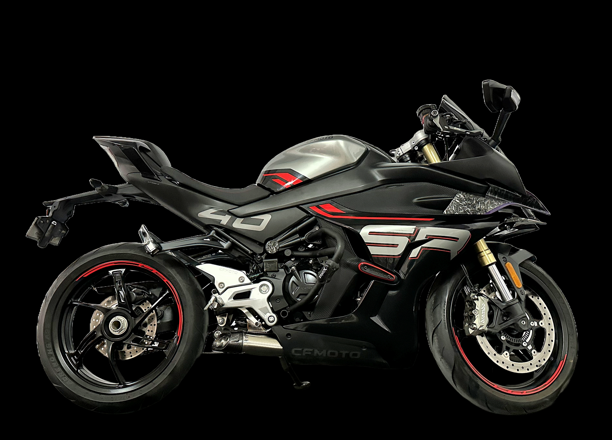 A motorcycle displayed prominently against a solid black background, highlighting its sleek design and exhaust from vandemon.