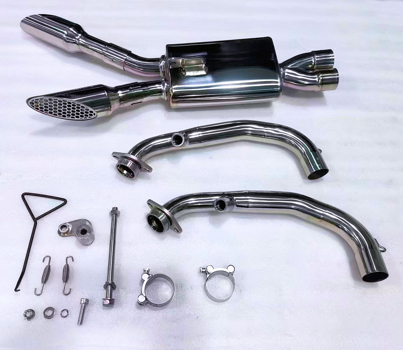Metal and carbon fiber automotive parts on dark surface.