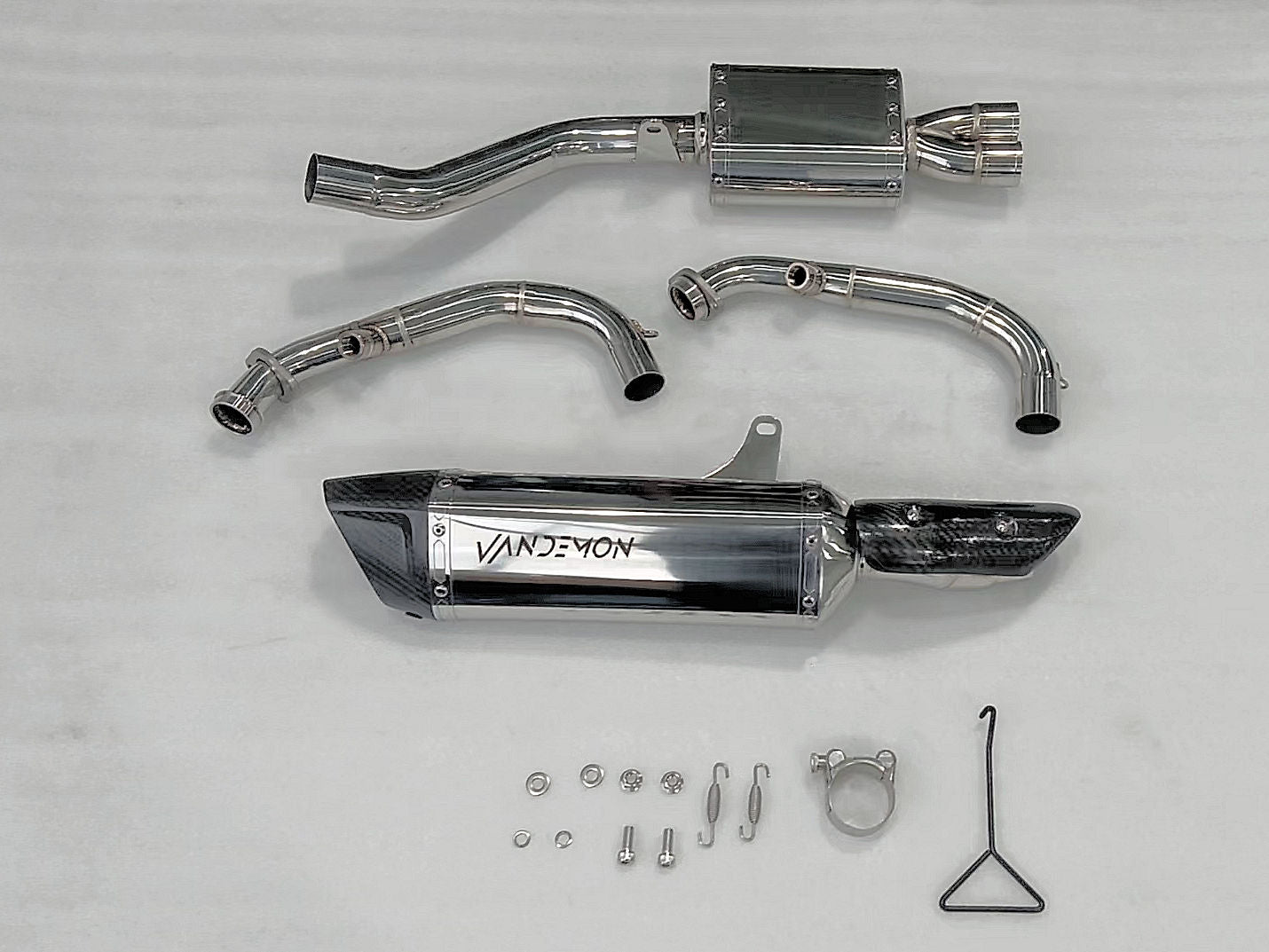 A collection of motorcycle exhaust pipes and various parts arranged on a workbench