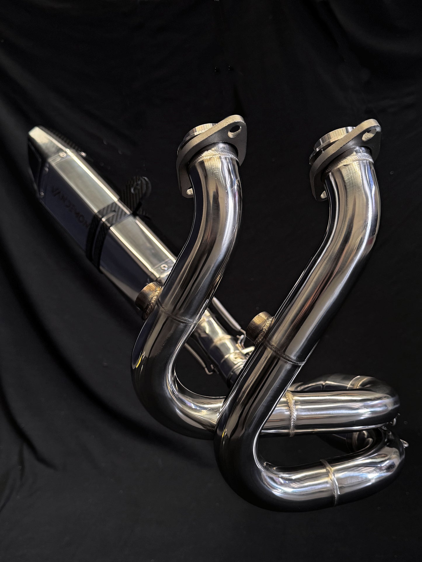 Dark background highlighting motorcycle dual-exhaust system.