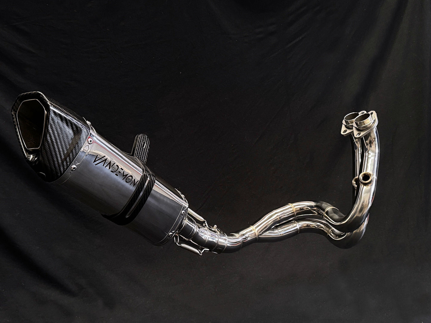 Modern motorcycle exhaust system with intricate details, close-up.