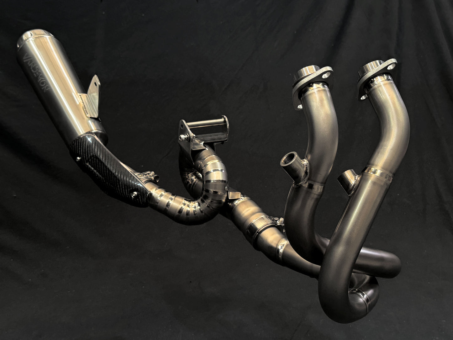 Modern design of motorcycle dual-exhaust against dark backdrop.