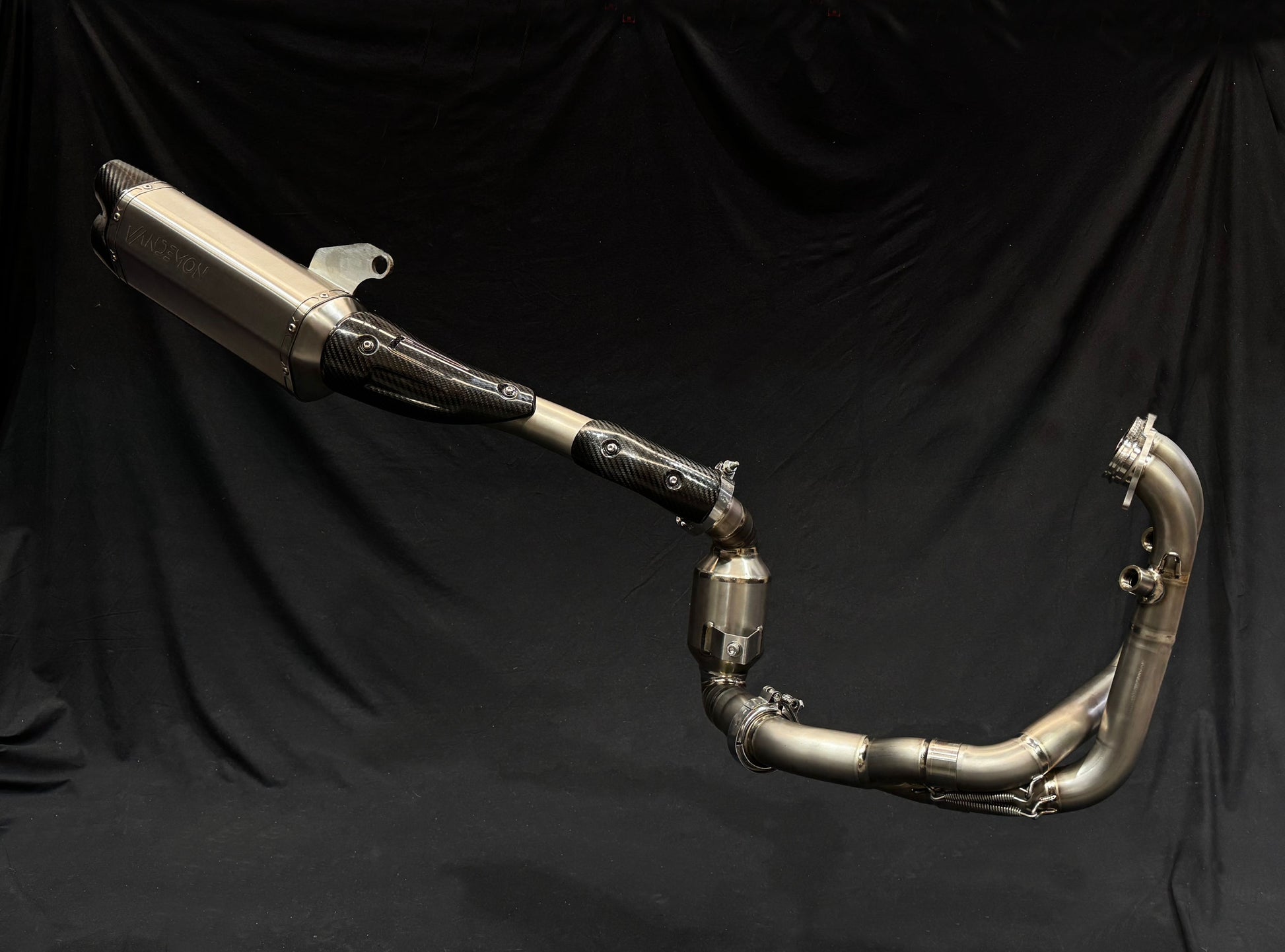 Close-up of a motorcycle exhaust pipe against a solid black background