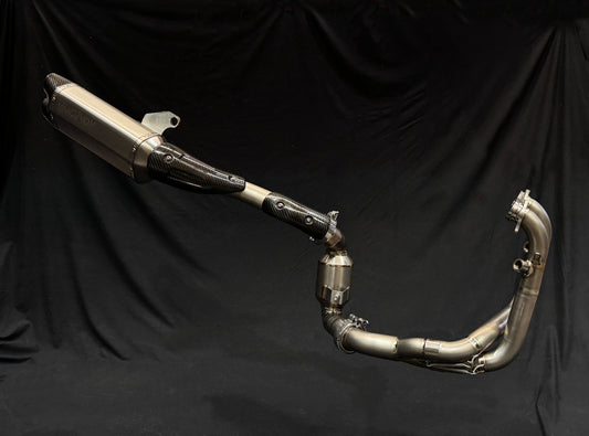 Close-up of a motorcycle exhaust pipe against a solid black background