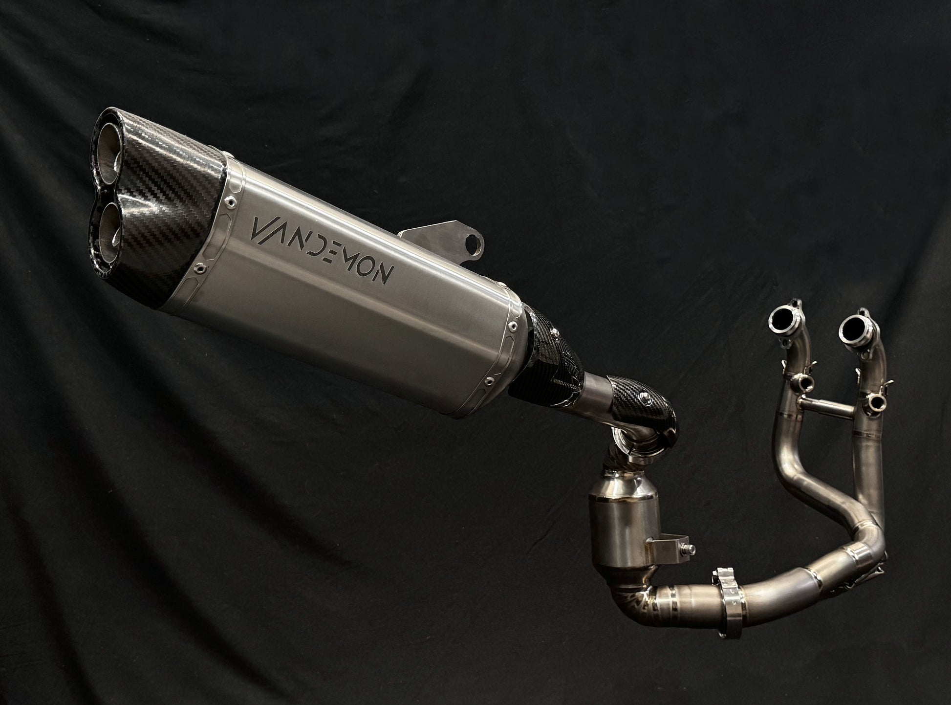 A sleek motorcycle exhaust pipe displayed on a black background