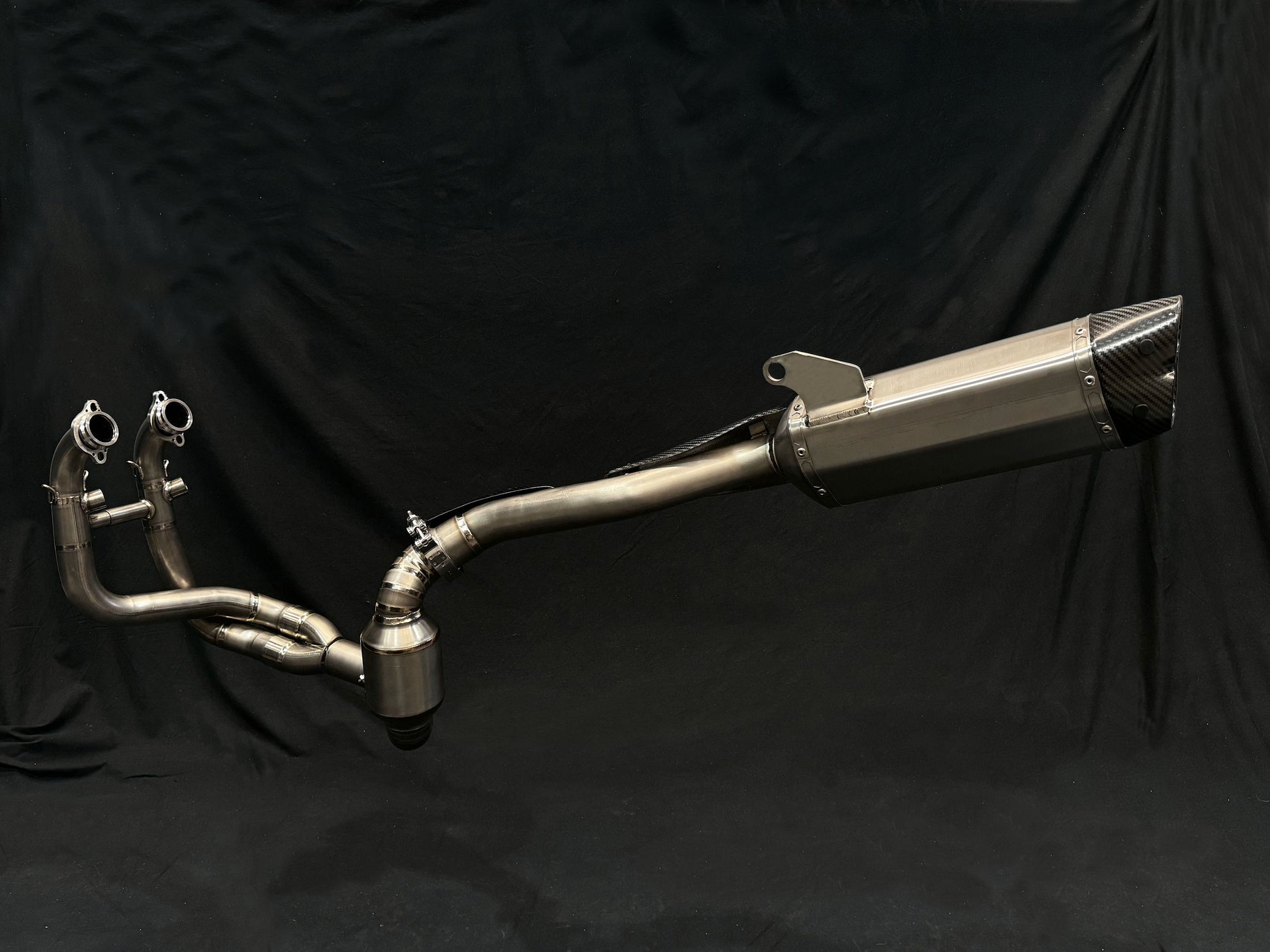 motorcycle exhaust pipe displayed on a black background