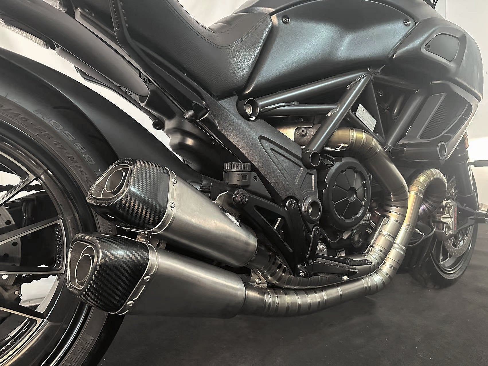 A black motorcycle's titanium mufflers baffles in.