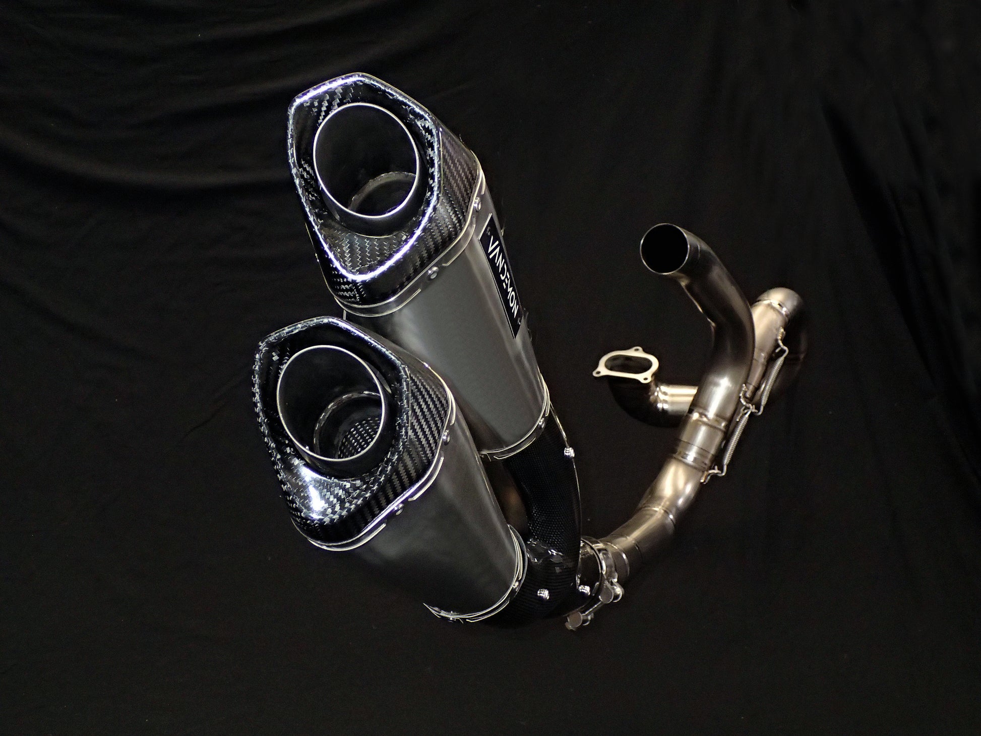 Sleek, metallic dual-exhaust system on motorcycle, close-up view.