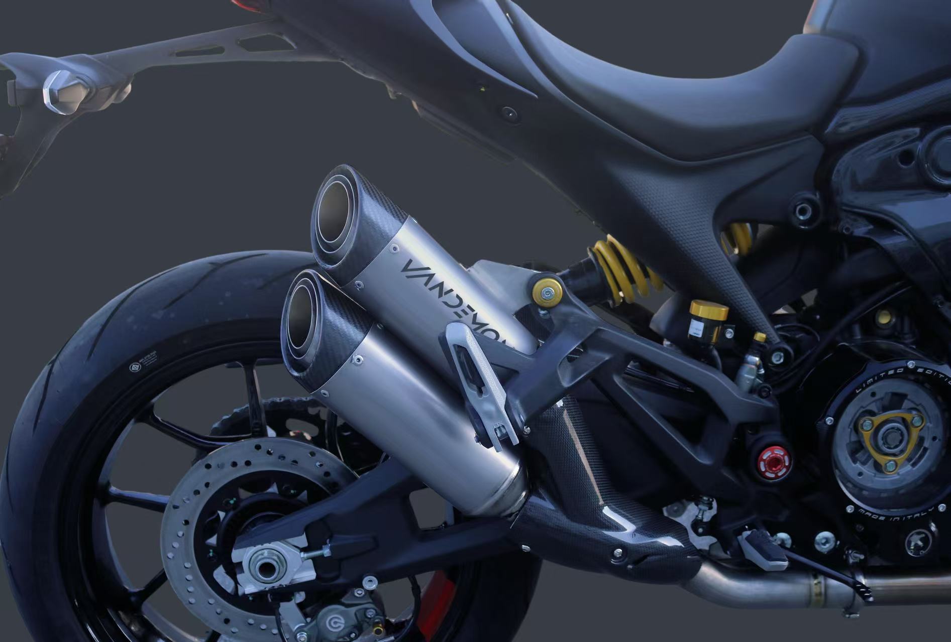 Close-up of a motorcycles rear section showing a dual exhaust system with Vandemon branding.