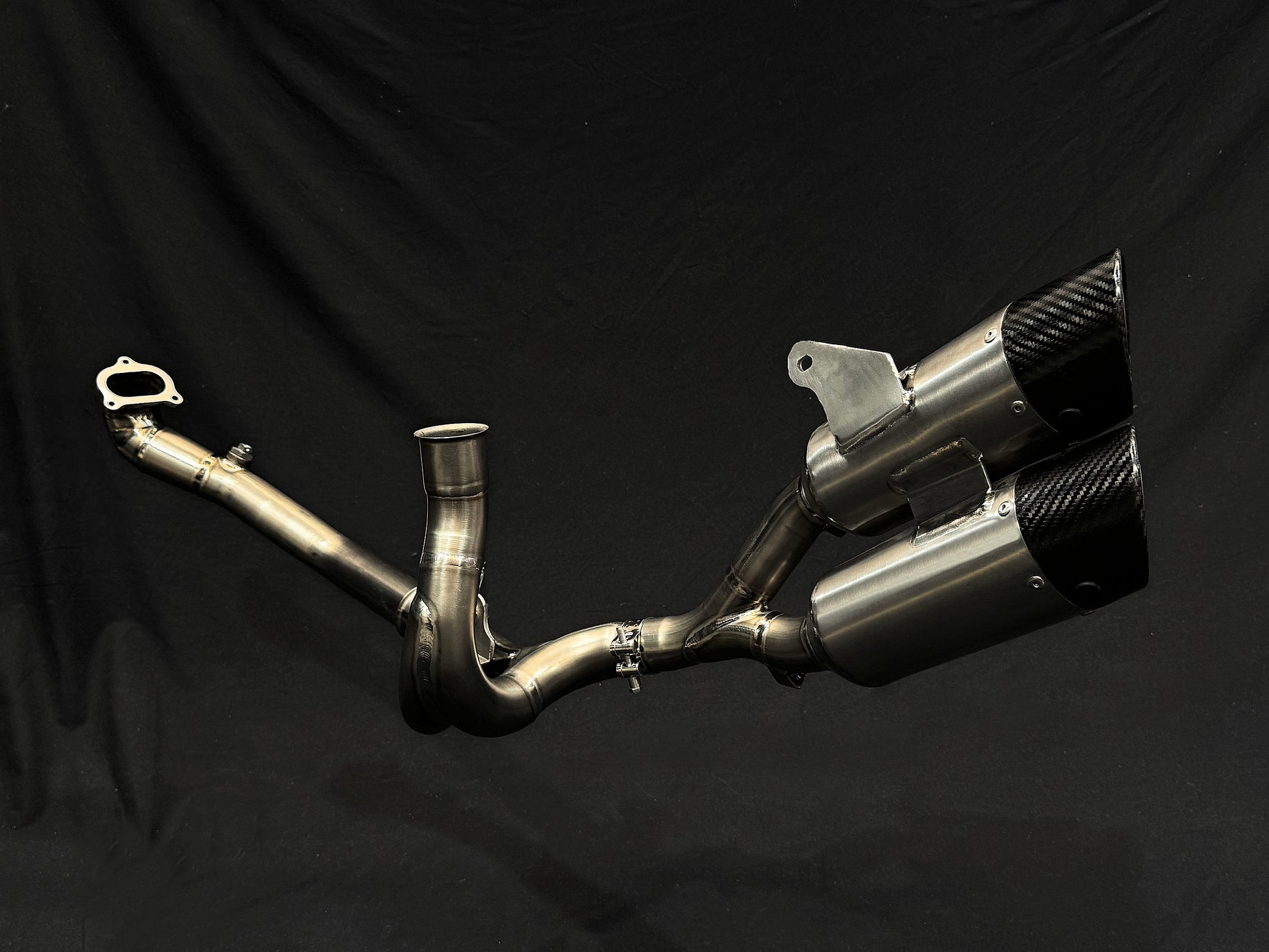 Modern design of motorcycle dual-exhaust against dark backdrop.