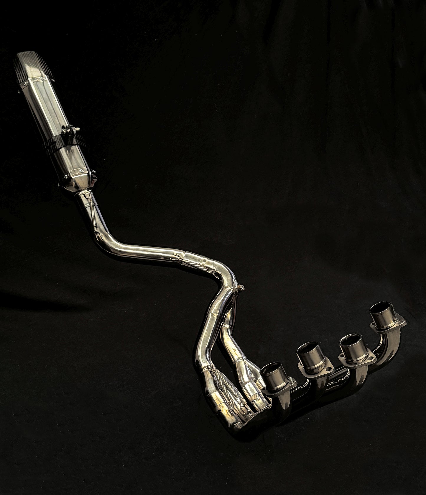 Close-up of a silver exhaust pipe with a dark black backdrop