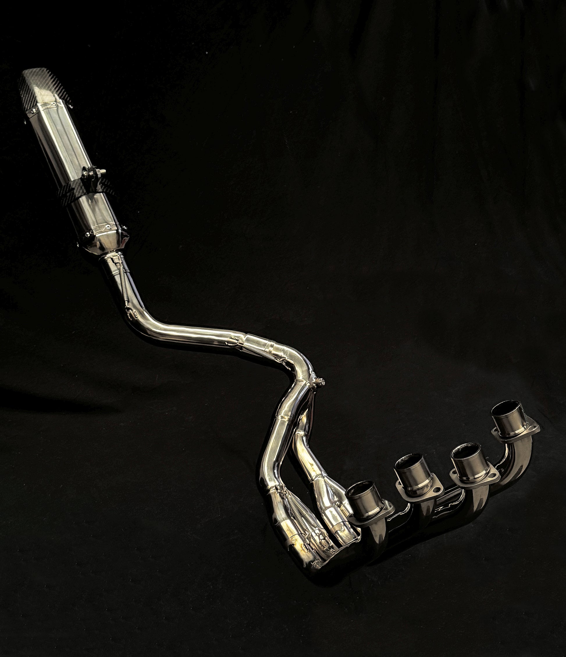 Close-up of a silver exhaust pipe with a dark black backdrop