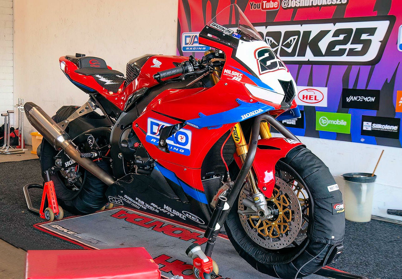 A red motorcycle displayed on a stand, highlighting its sporty appearance and polished finish.