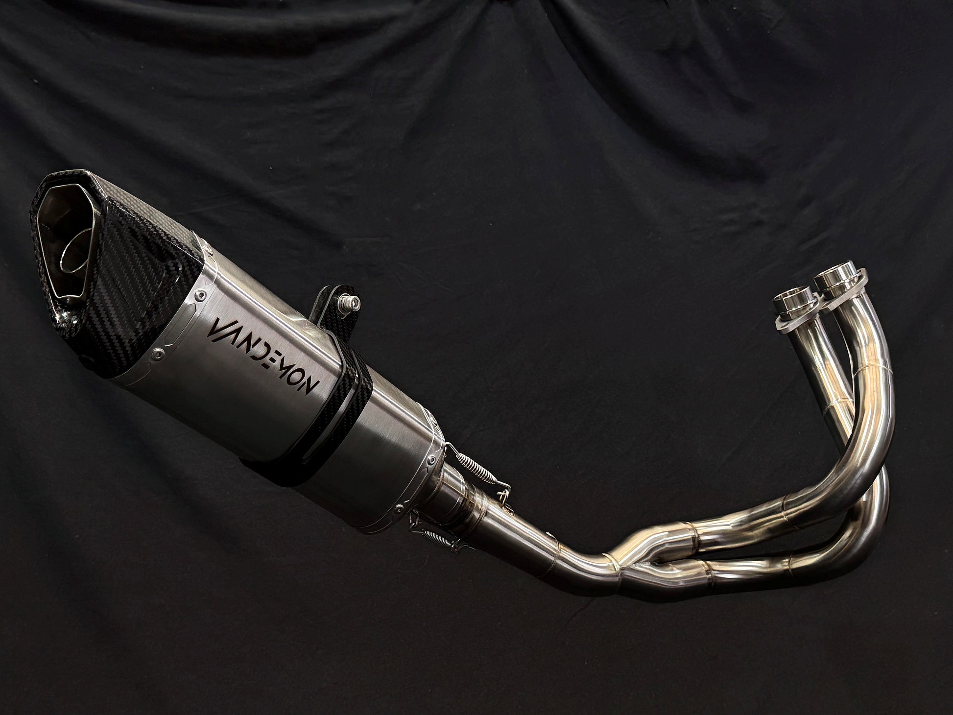 A close up view of a motorcycle's stainless steel exhausts.