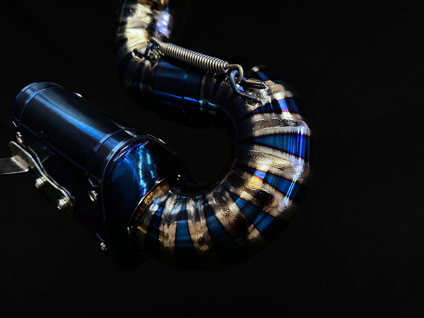 A close up view of a motorcycle exhausts component,titanium slip on pie cut.