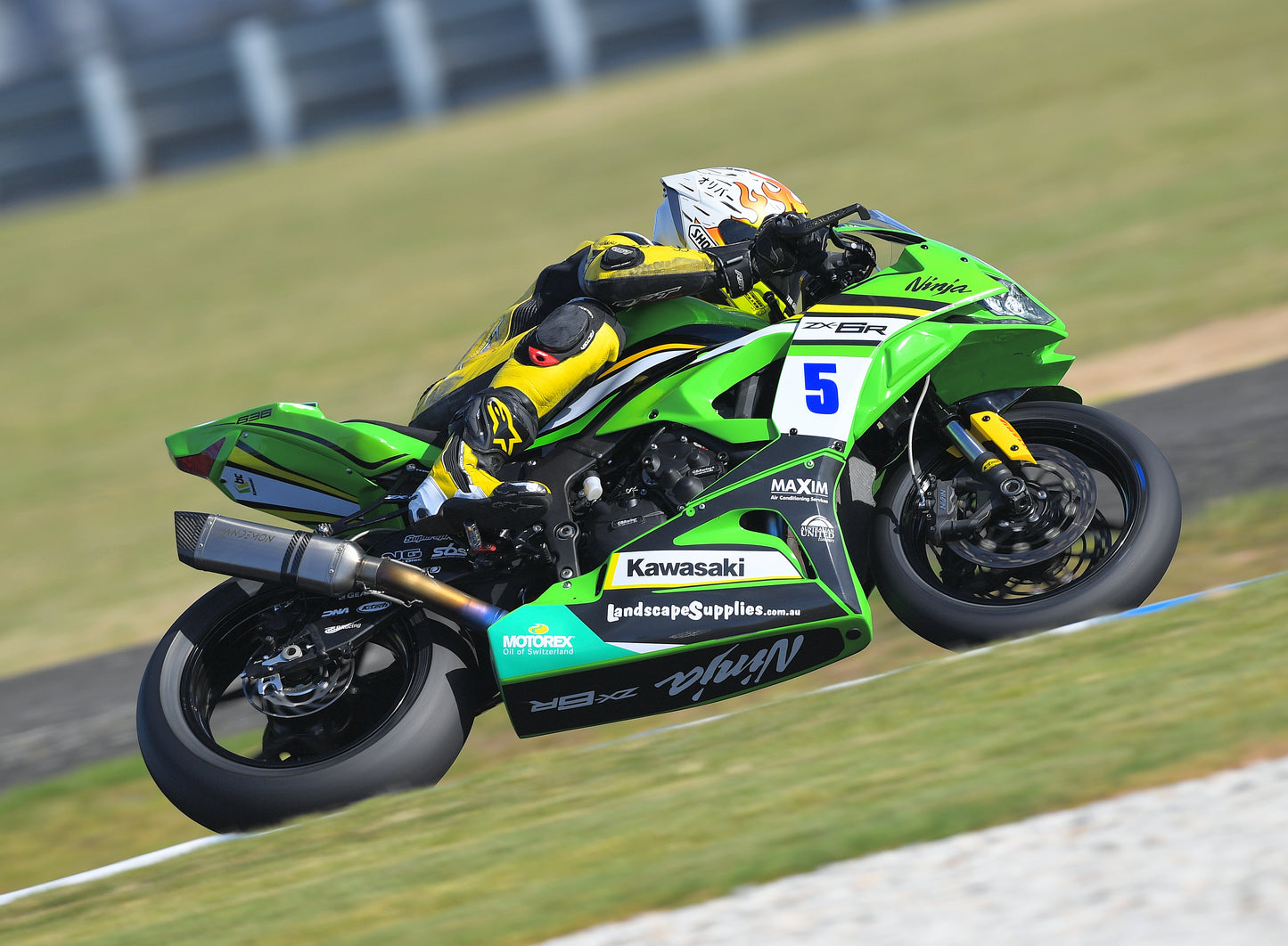 A man riding a green motorcycle participating in a race.