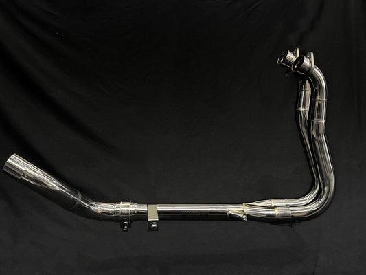 Close-up of dual-exhaust motorcycle exhaust system against dark background.