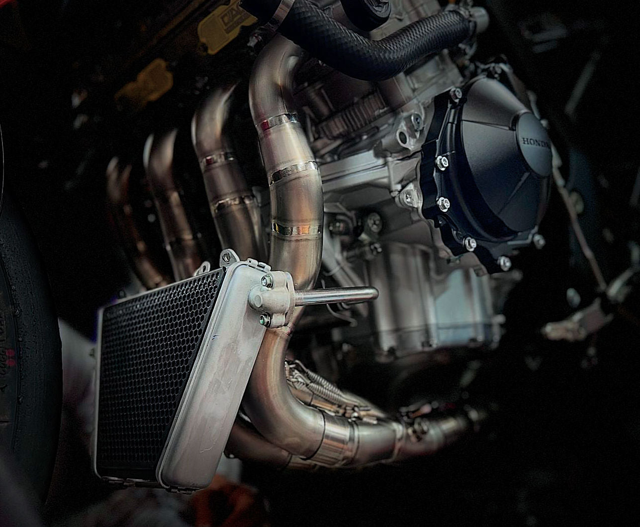 Close-up of a motorcycle engine featuring a radiator and a fan, showcasing intricate mechanical components and design.