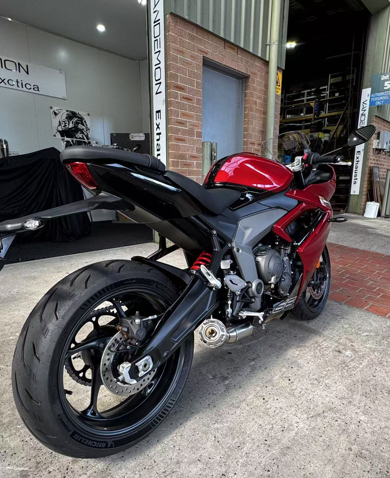 A red motorcycle is parked outside a building