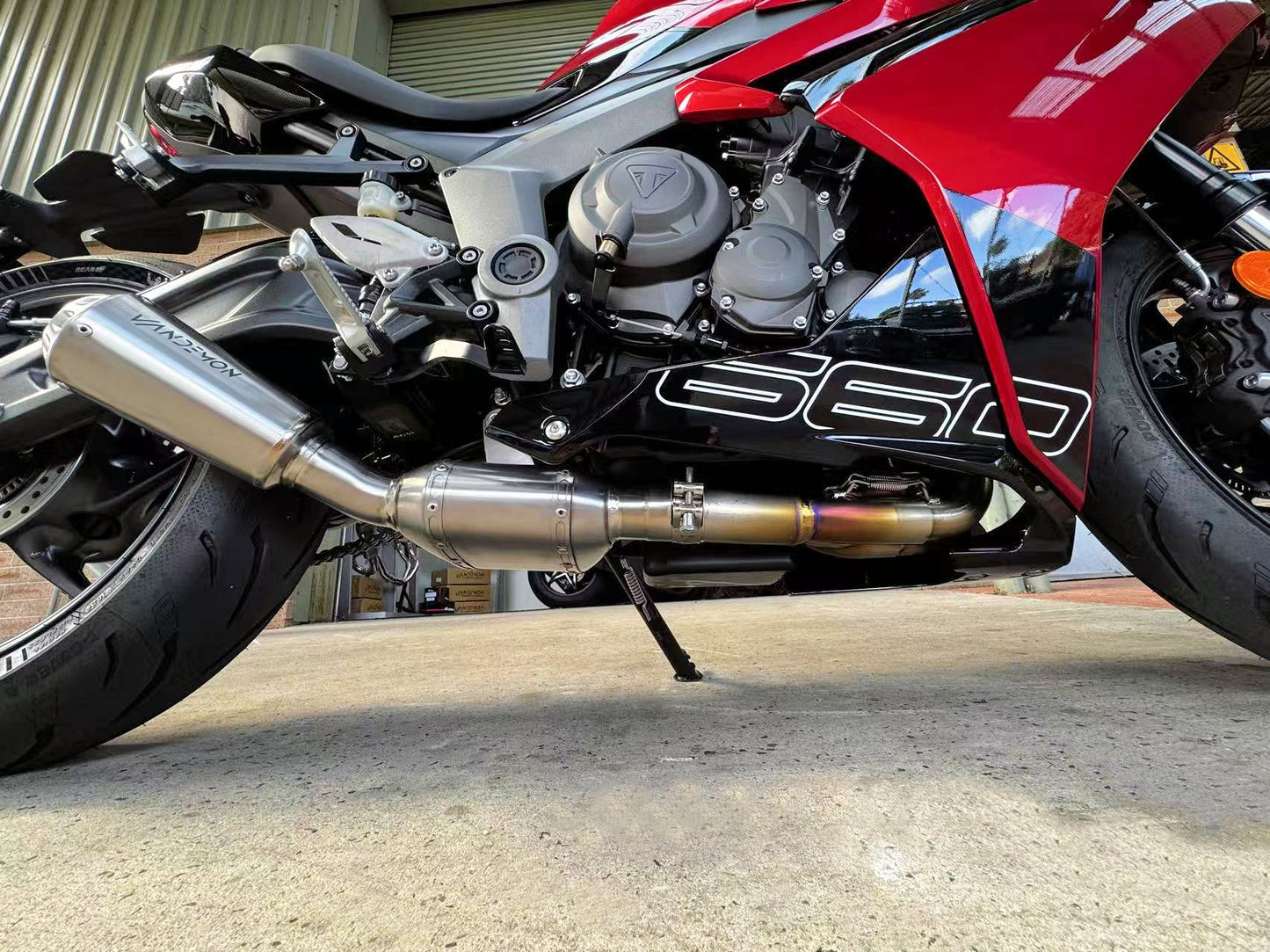 Close-up of a red motorcycle featuring a sleek exhaust pipe