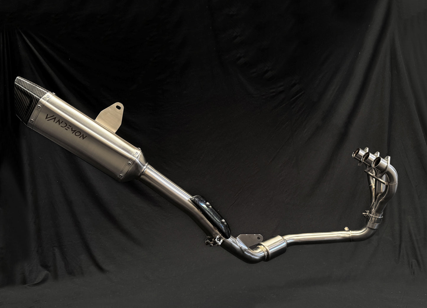 Light reflects off metallic dual-exhaust motorcycle system.