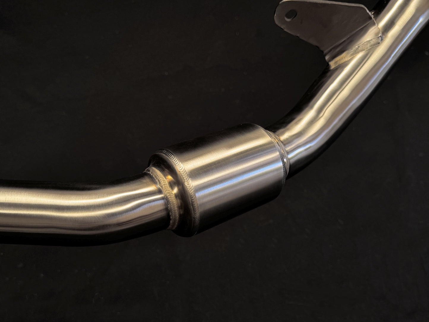Close-up of sleek, reflective dual-exhaust motorcycle system.