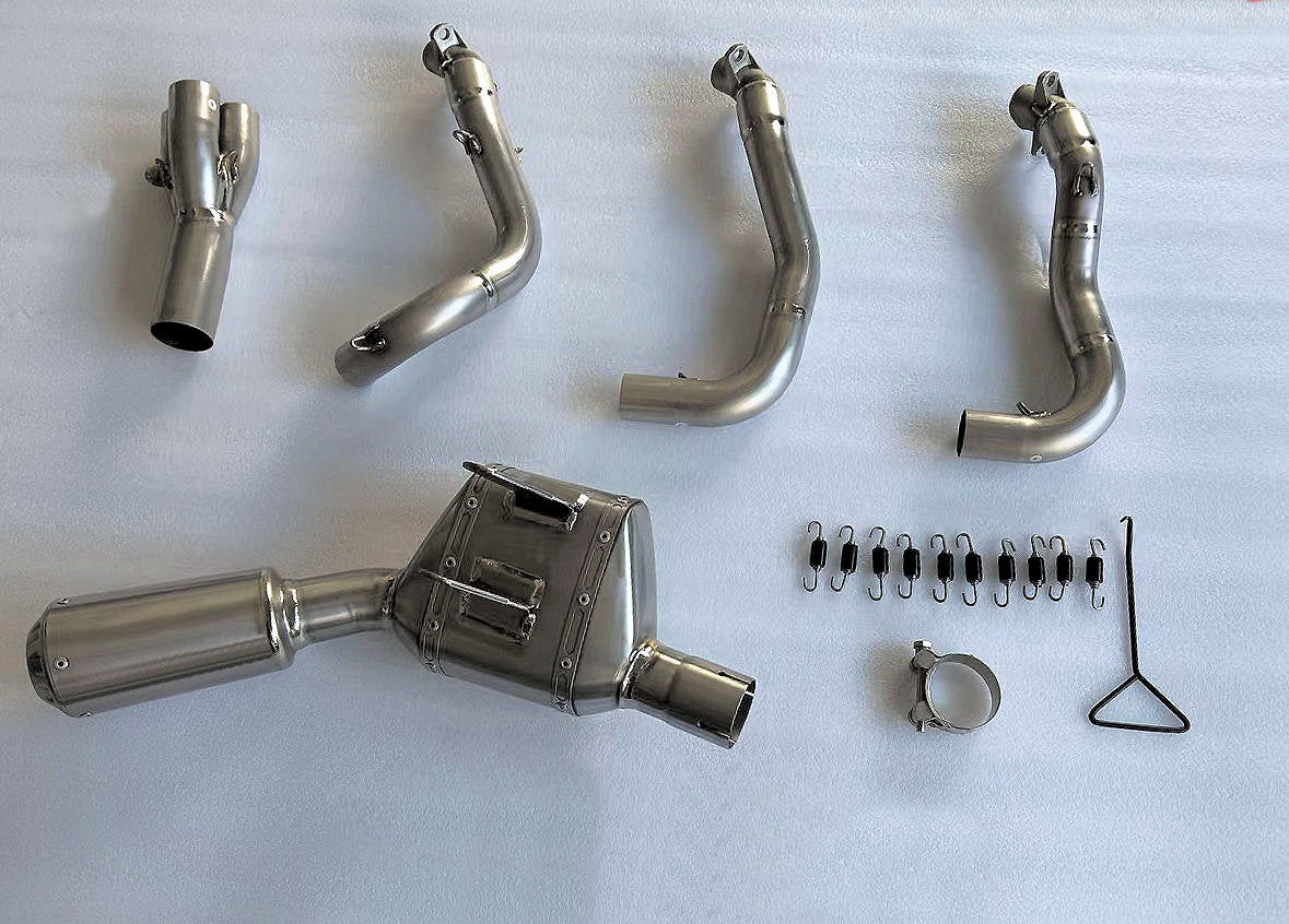 Automotive parts, metal and carbon fiber, arranged on a white surface.