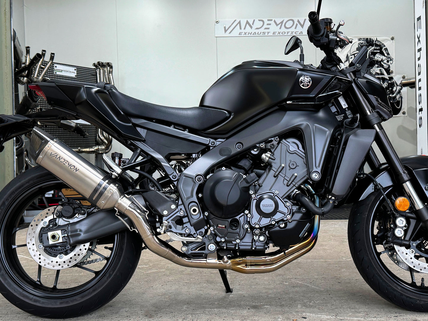 Black sport motorcycle parked, showcasing Vandemon exhaust.