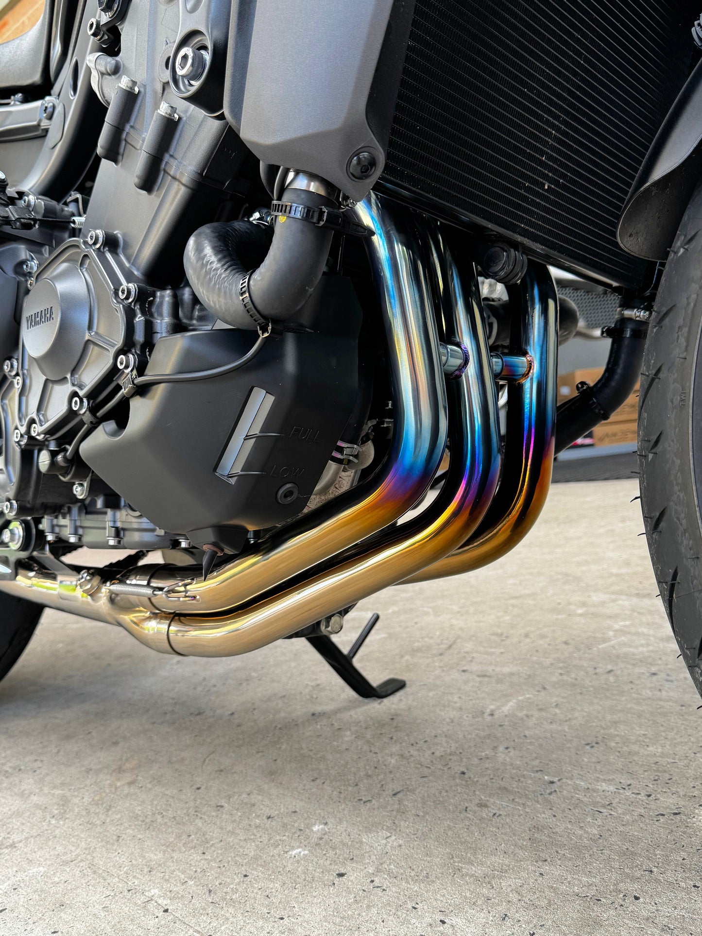 Close-up of a motorcycles exhaust pipes reflecting a rainbow of colors.