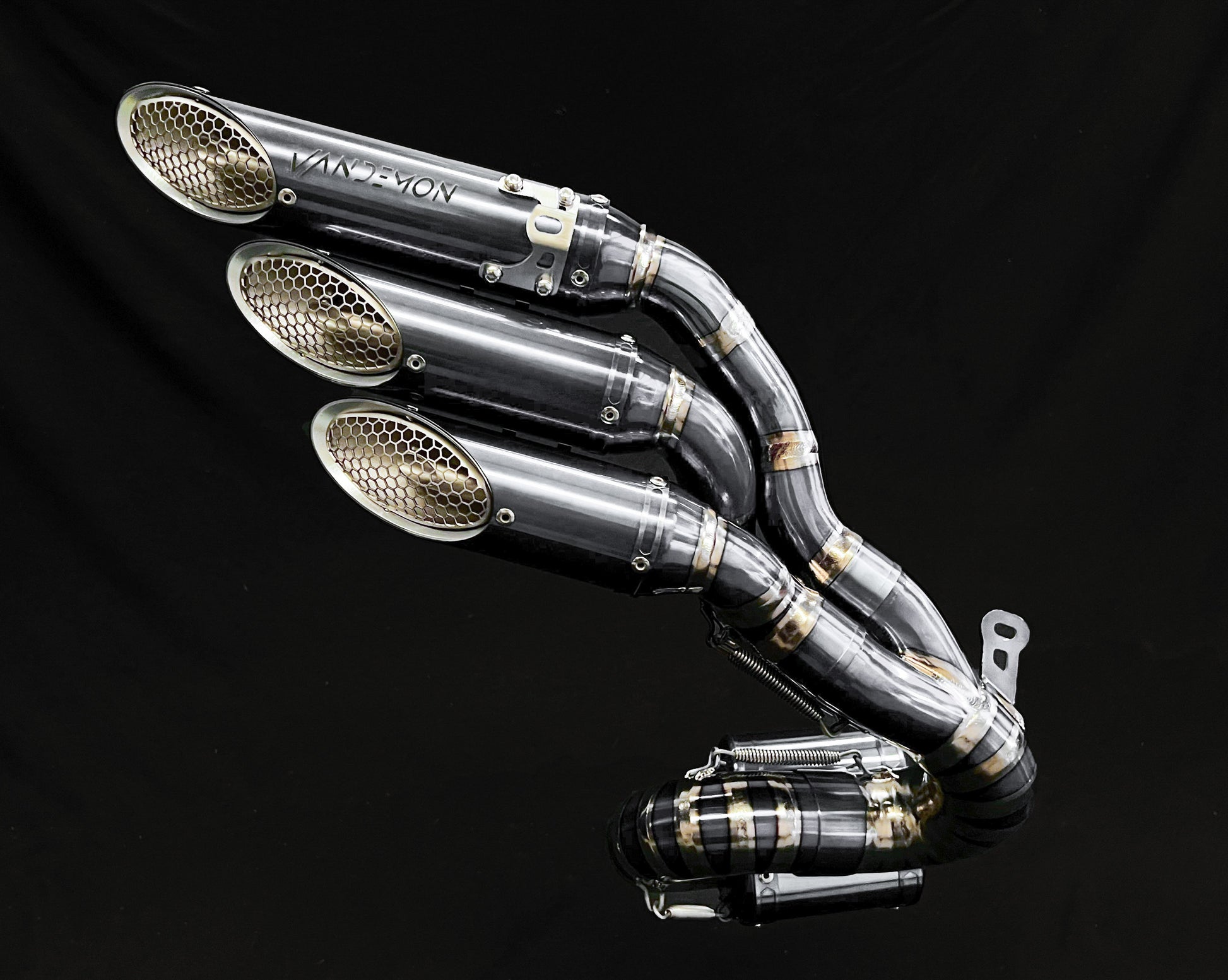 VANDemon motorcycle exhaust with three polished pipes merging into a collector